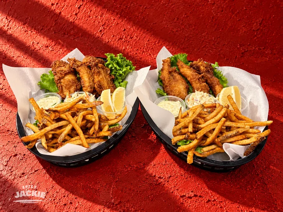 Two baskets of battered fish and fries with lemon